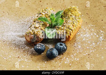 Gustosi eclari con pistacchi e cheesecake sui piatti Foto Stock