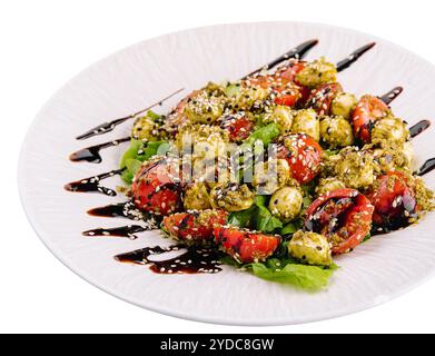 Insalata con pomodori e mozzarella con foglie di basilico e strisce di salsa di soia Foto Stock