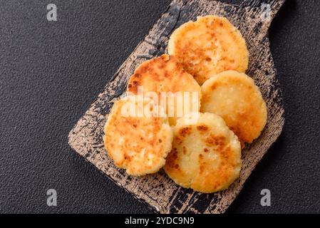 Deliziose frittelle di formaggio dolce fresco con uva passa e cannella su un piatto di ceramica Foto Stock