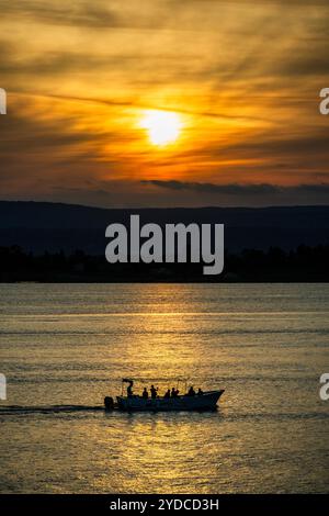 Sicilia, Italia. 25 ottobre 2024. Le barche turistiche passano il sole al tramonto nel porto - Autunno a Siracusa, Sicilia, Italia. Crediti: Guy Bell/Alamy Live News Foto Stock