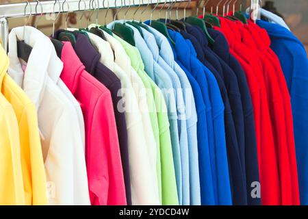 Magliette sportive multicolore appese in negozio Foto Stock