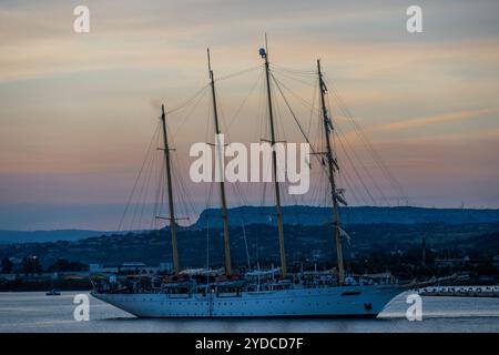 Sicilia, Italia. 25 ottobre 2024. Star Flyer, una nave Star Clipper, lascia il porto mentre il sole tramonta sul porto. Si tratta di moderne navi da crociera create per i passeggeri che amano le tradizioni dell'era delle navi a vela. Le navi sono lunghe 115 metri e trasportano 166 ospiti. Autunno a Siracusa, Sicilia, Italia. Crediti: Guy Bell/Alamy Live News Foto Stock