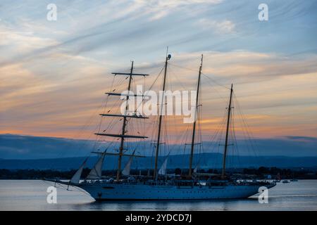 Sicilia, Italia. 25 ottobre 2024. Star Flyer, una nave Star Clipper, lascia il porto mentre il sole tramonta sul porto. Si tratta di moderne navi da crociera create per i passeggeri che amano le tradizioni dell'era delle navi a vela. Le navi sono lunghe 115 metri e trasportano 166 ospiti. Autunno a Siracusa, Sicilia, Italia. Crediti: Guy Bell/Alamy Live News Foto Stock