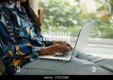 Donna che digita sul notebook mentre lavora in remoto Foto Stock