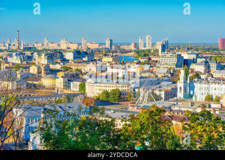 Kiev, Ucraina - 9 ottobre 2024: Vivace vista di Piazza Kontraktova e del quartiere Podil a Kiev, raffigurante la vita urbana con edifici e un Ferris W Foto Stock