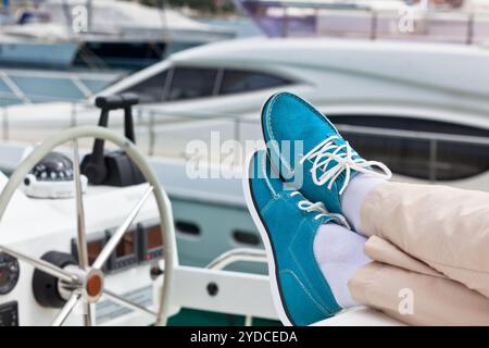 Un paio di zampe umane in pantaloni e brillanti top-sider blu sullo yacht Foto Stock