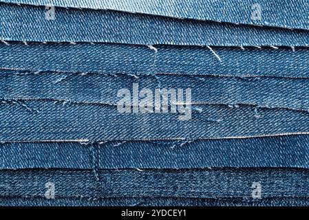 Texture da pezzi strappati di denim. Texture jeans. Materiale per cucire gli indumenti Foto Stock