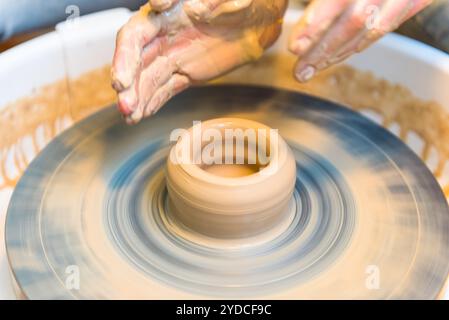 Le mani delle donne di un vasaio creano un vaso di terra Foto Stock