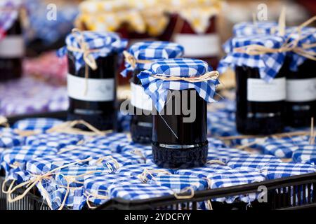 Molti barattoli per conserve con marmellata di scuro in un mercato. Inquadratura orizzontale Foto Stock