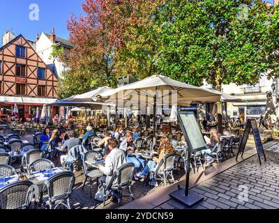 Folle del centro città sedute a tavoli all'aperto per pranzare a la Place Plumereau - Tours, Indre-et-Loire (37), Francia. Foto Stock