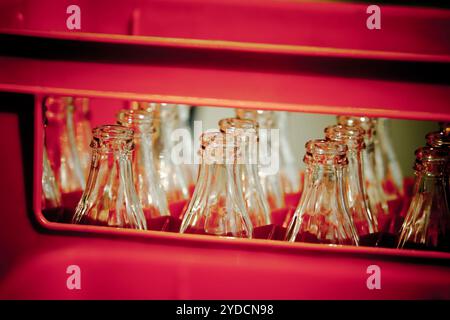 Rosso cassa di plastica vuote con bottiglie di vetro. Filtrata orizzontale shot Foto Stock