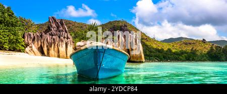 Vecchia barca da pesca sulla spiaggia tropicale dell'isola Curieuse alle Seychelles Foto Stock