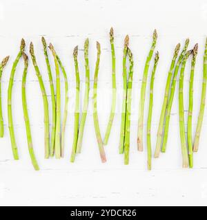 Asparagi verdi freschi su sfondo di legno bianco Foto Stock