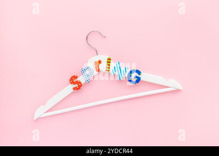 Appendiabiti bianchi con testo di vendita su sfondo rosa Foto Stock