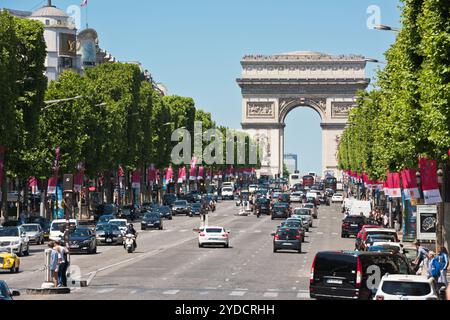 FRANCIA, PARIGI - 06 GIUGNO 2015: Traffico stradale su Les Champs-Elysees a Parigi con sullo sfondo il bellissimo Arco di Trionfo Foto Stock