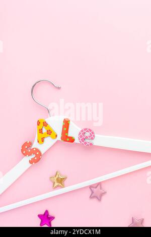 Appendiabiti bianchi con testo di vendita su sfondo rosa Foto Stock