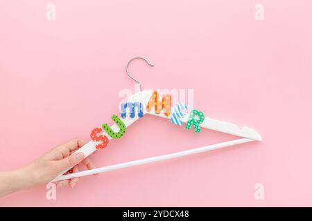 Appendiabiti bianchi con sfondo rosa con testo estivo Foto Stock