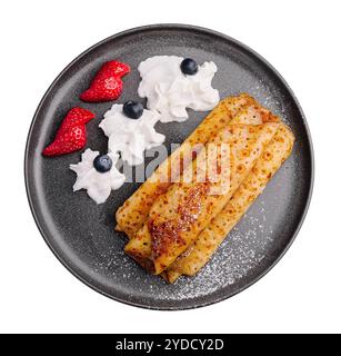 Frittelle in un piatto con fragole e panna montata Foto Stock