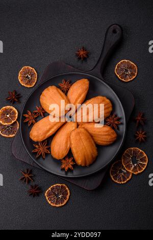 Tradizionali biscotti francesi madeleine con sapore di nocciola su sfondo di cemento scuro Foto Stock