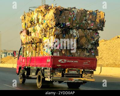 Giza, Egitto, 4 ottobre 2024: Un camion di trasporto pieno di rottami di carta di scarto di cartone marrone trasportati per il riciclaggio dopo essere stati raccolti, un camion ve Foto Stock