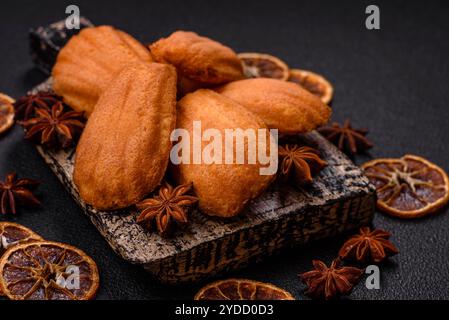 Tradizionali biscotti francesi madeleine con sapore di nocciola su sfondo di cemento scuro Foto Stock