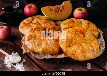 Cuocere torte tradizionali con mela e zucca su tavola di legno Foto Stock