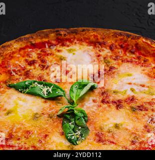 Pizza Margherita con basilico su pietra nera Foto Stock