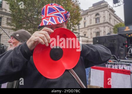 Westminster, Londra, Regno Unito. 26 ottobre 2024 Un sostenitore di estrema destra con un grande papavero della legione Britannica mentre migliaia di sostenitori di estrema destra dovrebbero partecipare ad un raduno programmato di Tommy Robinson a Downing Street. Tommy Robinson, alias Stephen Yaxley-Lennon, non sarà presente ed è stato rimesso in custodia. Amer Ghazzal/Alamy Live News Foto Stock