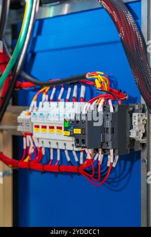 Primo piano di un armadio elettrico che mette in evidenza fusibili, fili e connettori, componenti essenziali per una distribuzione sicura ed efficiente dell'alimentazione in vari settori Foto Stock