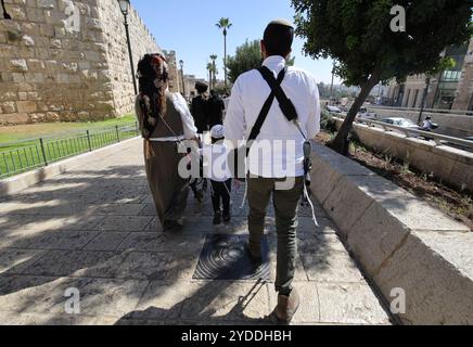 Un uomo porta un fucile mentre cammina a Gerusalemme, Israele, il 20 ottobre 2024. Foto di Raquel G. Frohlich. Foto Stock