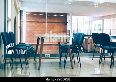 Sala coworking informale per freelance creativi con tavoli e sedie. Interni confortevoli e contemporanei per lavorare in luoghi pubblici della città Foto Stock