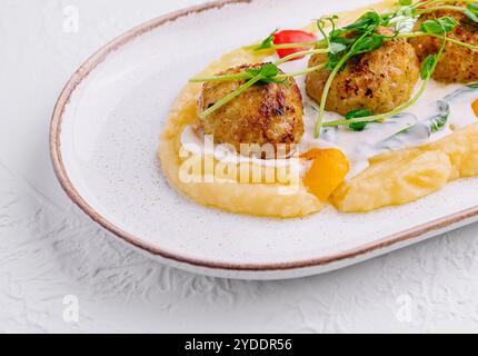 Polpette con purè di patate su un piatto bianco Foto Stock