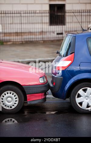 Due strettamente parcheggio auto su una strada di Parigi Foto Stock