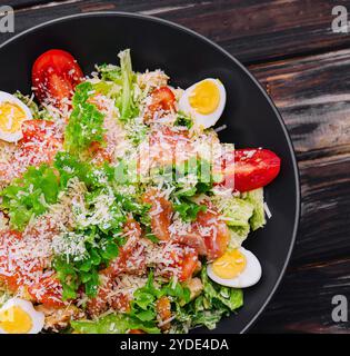 Insalata con salmone, lattuga, uova sode, pomodori ciliegini e parmigiano Foto Stock