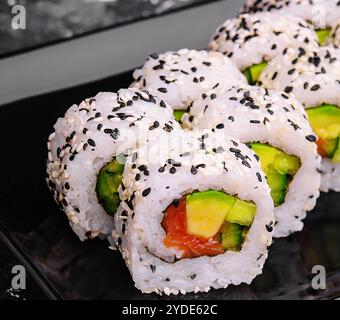 Delizioso sushi roll all'avocado con salmone Foto Stock