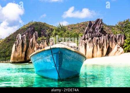 Vecchia barca da pesca sulla spiaggia tropicale dell'isola Curieuse alle Seychelles Foto Stock