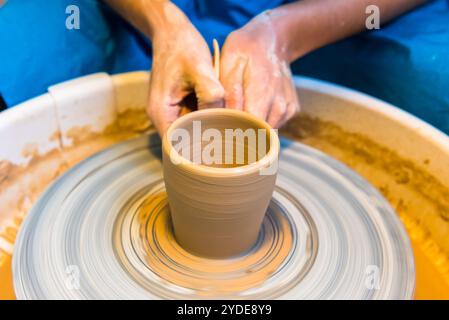 Le mani delle donne di un vasaio creano un vaso di terra Foto Stock