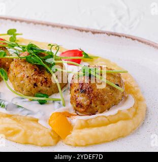 Polpette con purè di patate su un piatto bianco Foto Stock