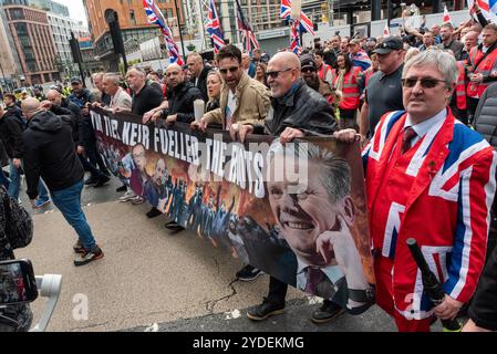 Westminster, Londra, Regno Unito. 26 ottobre 2024. I sostenitori di Stephen Yaxley-Lennon (alias Tommy Robinson) stanno prendendo parte a una marcia di protesta verso Whitehall. I temi della protesta includono l'immigrazione, e una protesta opposta organizzata da Stand Up to Racism sta marciando verso l'altra estremità di Whitehall. La polizia metropolitana e le unità redatte da altre parti partecipano in numero per scoraggiare la violenza. Striscione anti Keir Starmer Foto Stock