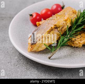 Bistecca di pesce alla griglia e verdure su un piatto Foto Stock