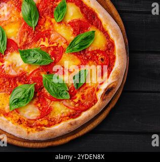 Pizza Margherita su sfondo in legno nero Foto Stock