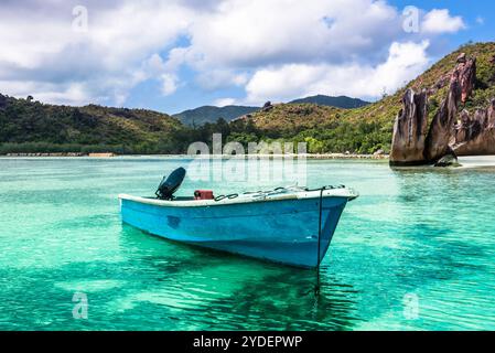 Vecchia barca da pesca sulla spiaggia tropicale dell'isola Curieuse alle Seychelles Foto Stock