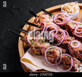 Kebab di maiale su spiedini su tavola di legno Foto Stock