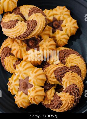 Biscotti friabili con cioccolato su piatto nero Foto Stock