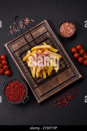 Patatine fritte croccanti con pezzi di pancetta, sale e spezie Foto Stock