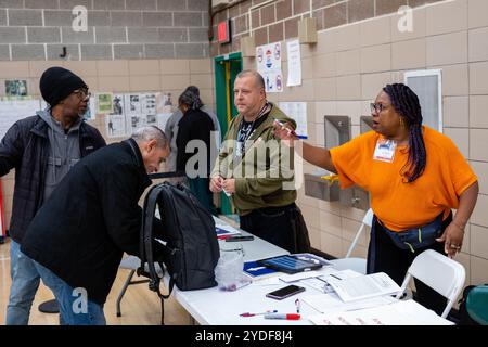 Brooklyn, New York, Stati Uniti. 26 ottobre 2024. Il primo giorno di votazione anticipata nello stato di New York, alcune persone arrivarono 40 minuti prima che i sondaggi aprivano alle 8:00 alla Edward R. Murrow High School di Midwood per assicurarsi che avessero un posto in fila. Lavoratori elettorali. Crediti: Ed Lefkowicz/Alamy Live News Foto Stock