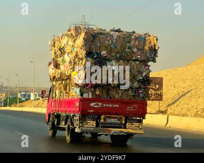 Giza, Egitto, 4 ottobre 2024: Un camion di trasporto pieno di rottami di carta di scarto di cartone marrone trasportati per il riciclaggio dopo essere stati raccolti, un camion ve Foto Stock