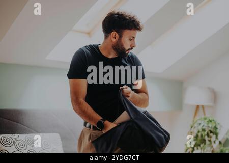Giovane studente che organizza la sua borsa in una camera luminosa e moderna Foto Stock