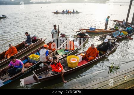 Thailandia. 25 ottobre 2024. Una vista dei monaci seduti su barche di legno con i loro aiutanti e autisti prima della partenza per raccogliere elemosine da persone che aspettano sulla riva del fiume Chao Phraya. La tradizione di dare l'elemosina a un centinaio di monaci a Pathum Thani, Thailandia, è una cerimonia buddista secolare che si svolge lungo fiumi e canali dopo la fine della Quaresima buddista. I monaci si riuniscono in barca per ricevere offerte dalla gente del posto, che prepara il cibo e partecipa alla preparazione del merito. Questo evento celebra la comunità, la fede e il patrimonio culturale. Credito: SOPA Images Limited/Alamy Live News Foto Stock