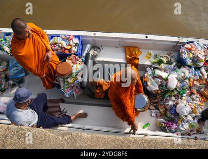 Thailandia. 25 ottobre 2024. Un monaco in piedi su una barca a remi e un altro che raccoglie elemosine, sul fiume Chao Phraya al tempio Wat Chin Wararam Worawihan, nella provincia di Pathum Thani, Thailandia. La tradizione di dare l'elemosina a un centinaio di monaci a Pathum Thani, Thailandia, è una cerimonia buddista secolare che si svolge lungo fiumi e canali dopo la fine della Quaresima buddista. I monaci si riuniscono in barca per ricevere offerte dalla gente del posto, che prepara il cibo e partecipa alla preparazione del merito. Questo evento celebra la comunità, la fede e il patrimonio culturale. Credito: SOPA Images Limited/Alamy Live News Foto Stock